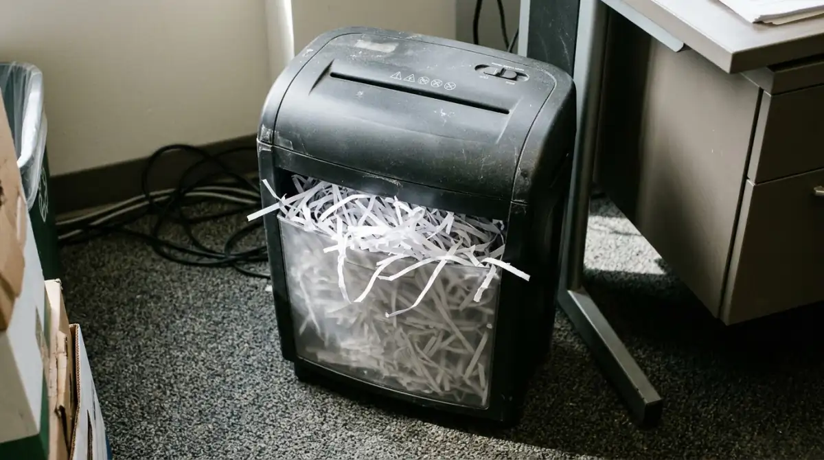 A server rack with indicator lights in a dim data room and a paper contract on a nearby desk